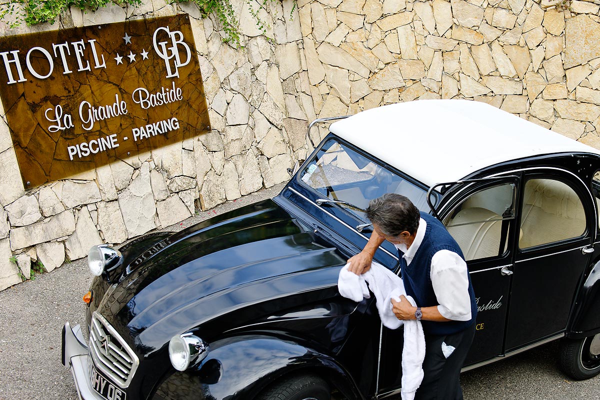A black car is parked in front of a sign that says hotel la grande bastide
