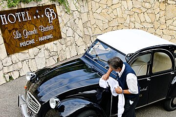 A black car is parked in front of a sign that says hotel la grande bastide