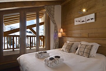 A hotel room with a large bed and a balcony