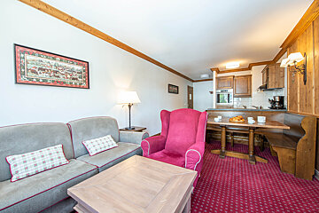 A living room with a couch a chair and a table