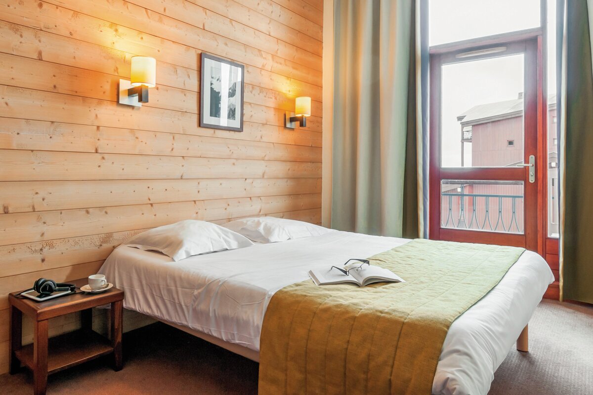 A hotel room with a bed and a book on it