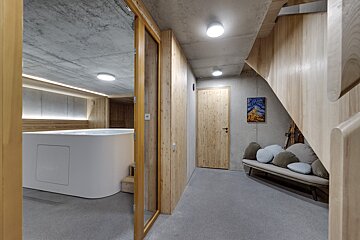 A wooden staircase leads to a room with a hot tub