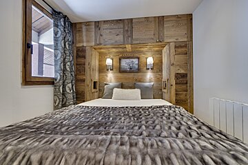 A bedroom with a bed and a picture on the wall