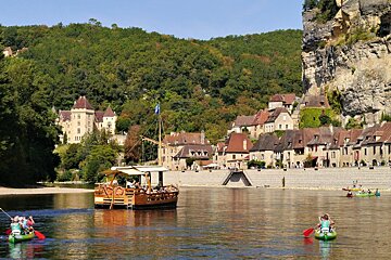 a view of canoes & a gabare on the river at la roque gageac