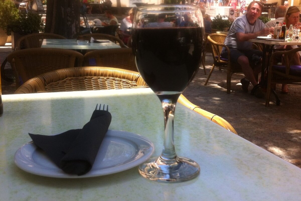 a glass of red wine and a side plate