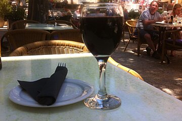 a glass of red wine and a side plate