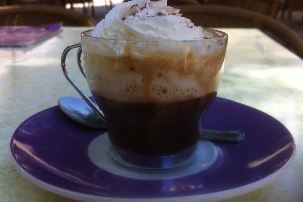 a small coffee with a big dollop of cream on top