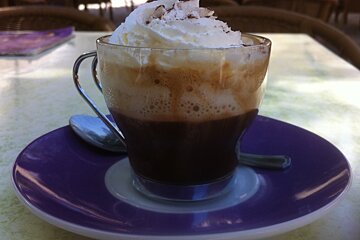 a small coffee with a big dollop of cream on top