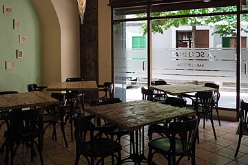4 dining tables and wooden chairs inside a restaurant