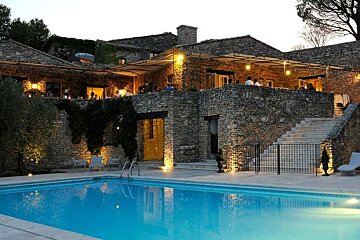 Swimming pool with old stone building in background lit up at night