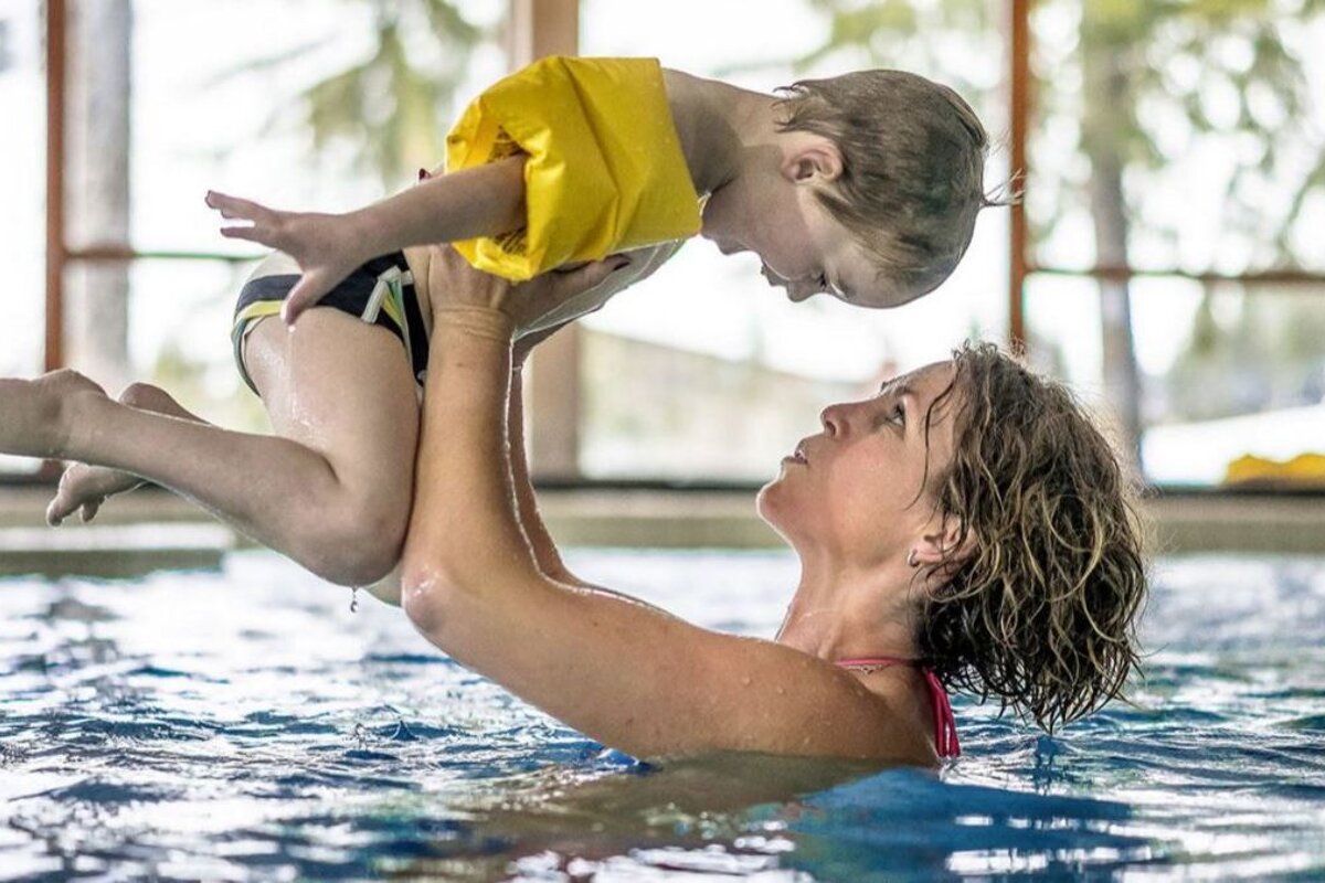a woman with a child in a pool