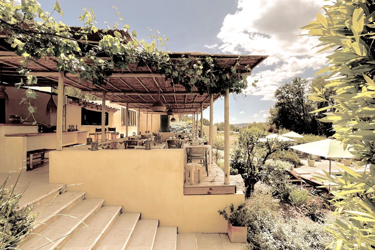A restaurant with tables and chairs under a canopy