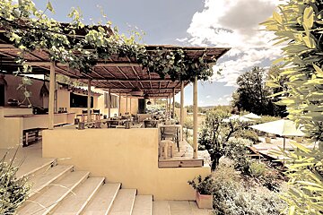 A restaurant with tables and chairs under a canopy