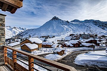 A snowy village with a mountain in the background