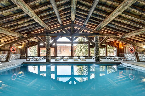 A large indoor swimming pool with a wooden roof