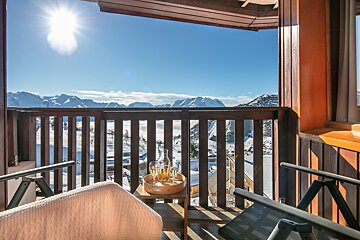 A balcony with a view of a snowy mountain range