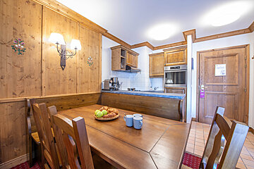 A wooden table with a bowl of apples on it