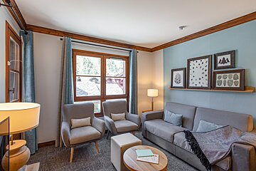 A living room with a couch and two chairs