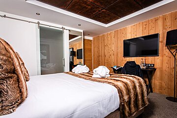 A bedroom with a sliding glass door and a flat screen tv