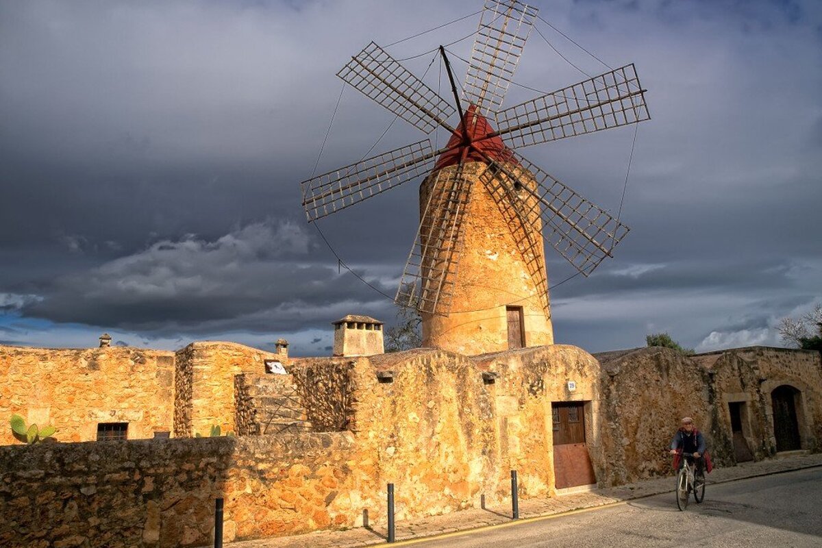 A person riding a bike in front of a windmill