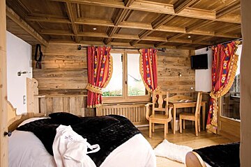 A bedroom with two beds and a table and chairs