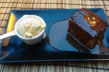 Sticky Toffee Pudding with Vanilla Ice Cream on black plate