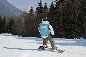 a snowboarder on a tree lined piste