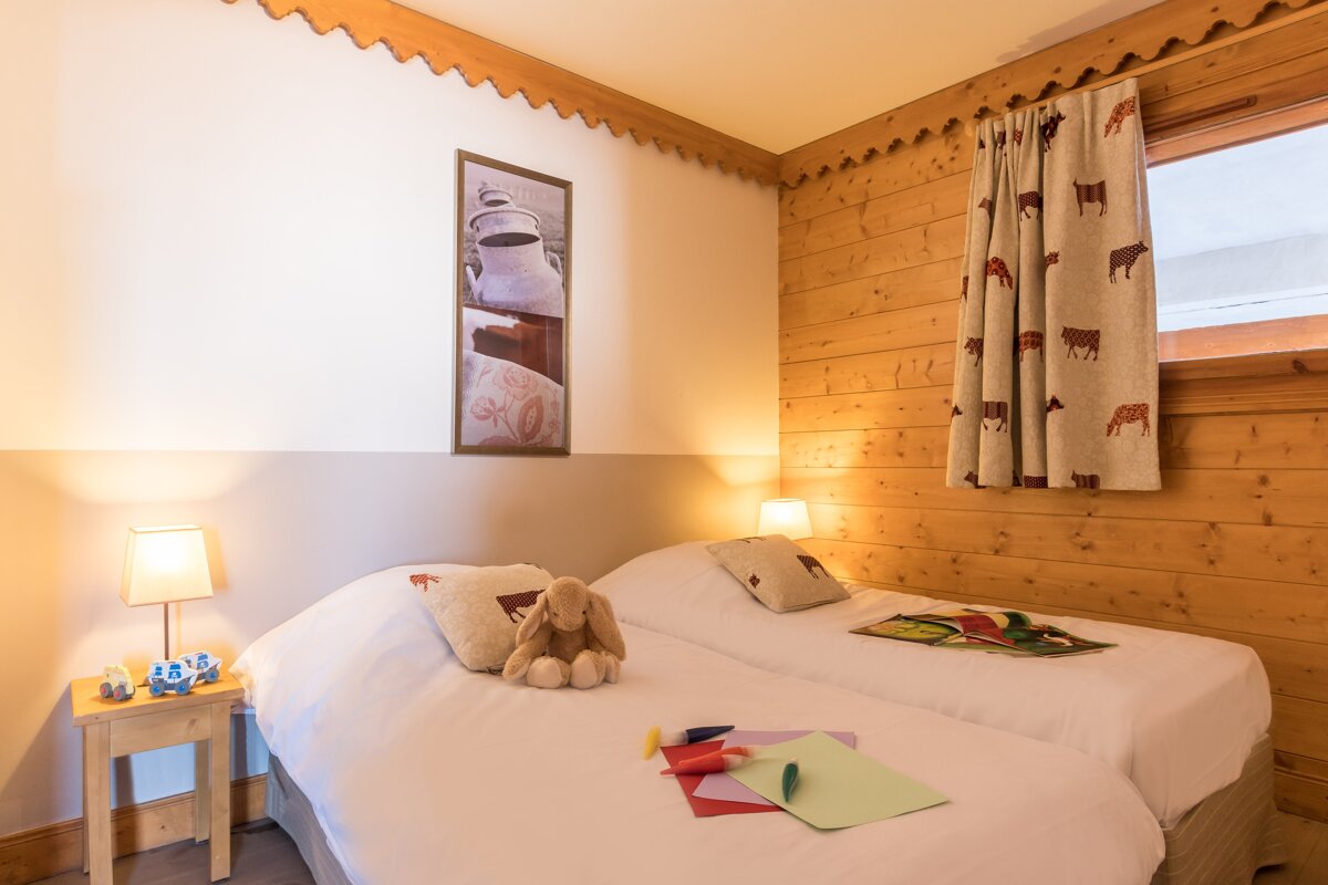 A bedroom with two beds and a picture on the wall