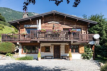 A chalet with a balcony and a sign that says ' l' ermitage ' on it