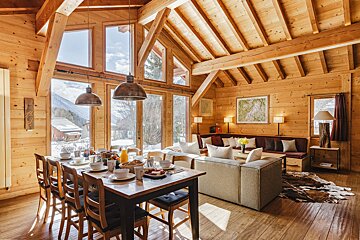 A wooden house with a dining table and chairs