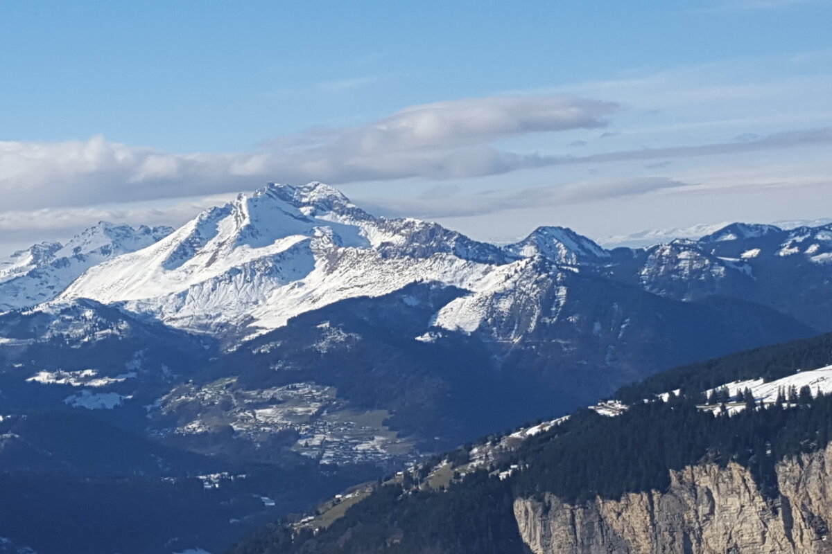 A snowy mountain range with a blue sky in the background