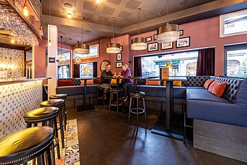 A man and woman sit at a table in a restaurant with a sign that says open