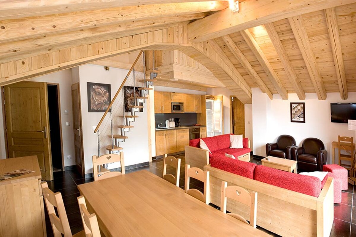 A living room with a red couch and a wooden table