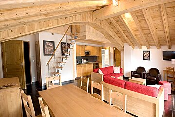 A living room with a red couch and a wooden table