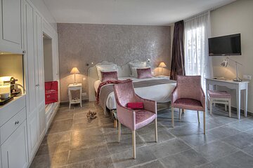 A hotel room with a bed and two chairs