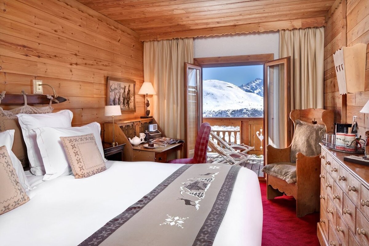 A bedroom with a large bed and a view of the mountains