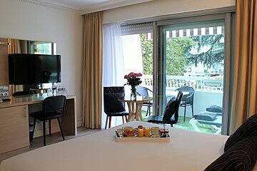 A hotel room with a tray of breakfast on the bed