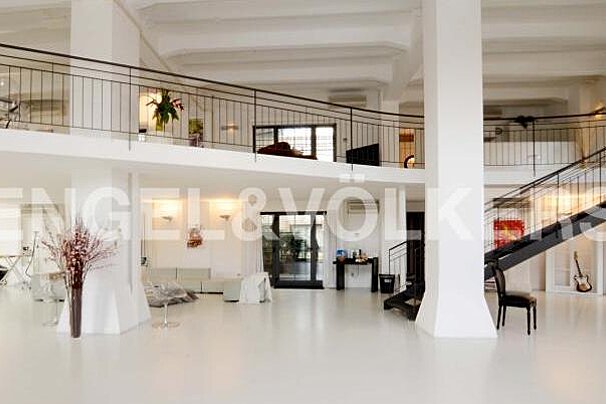A large white room with a staircase and a balcony