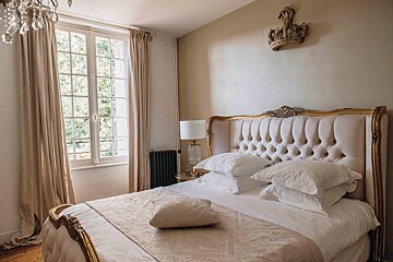 A bedroom with a bed and a crown on the wall