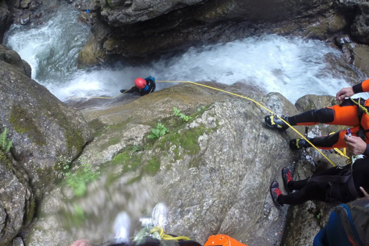 canyoneers descending into a river