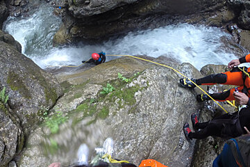 canyoneers descending into a river