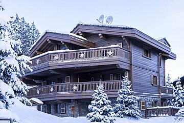 A large wooden house with snowflakes on the balconies