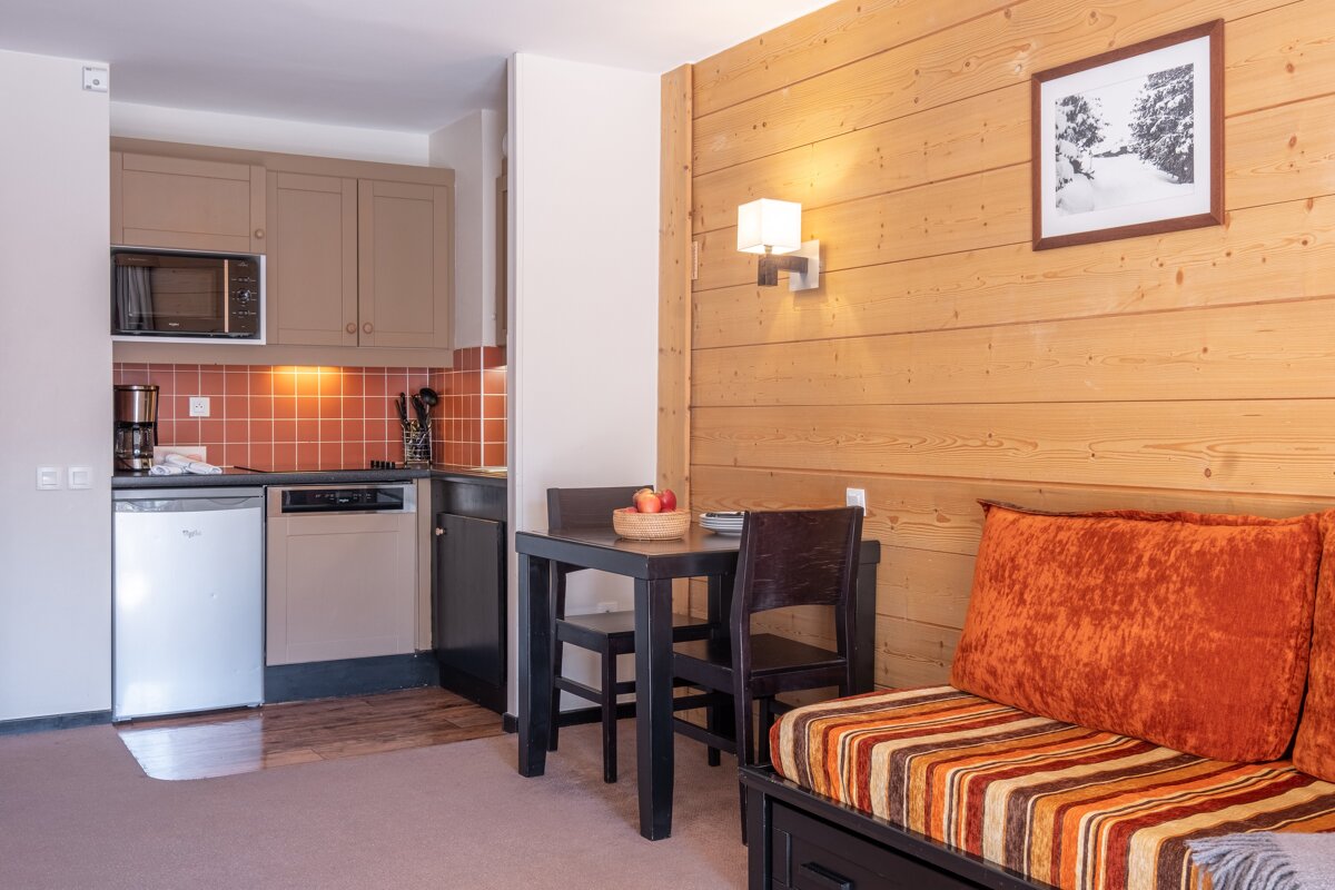 A kitchen with a table and chairs and a picture on the wall