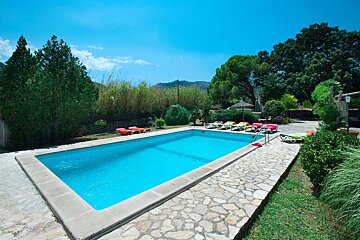 A large swimming pool surrounded by chairs and trees