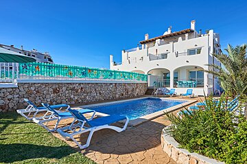 A large white house with a swimming pool in front of it