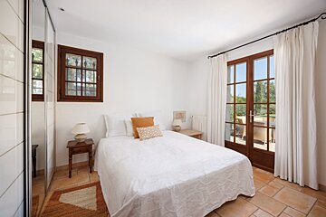 A bedroom with a large bed and a sliding glass door