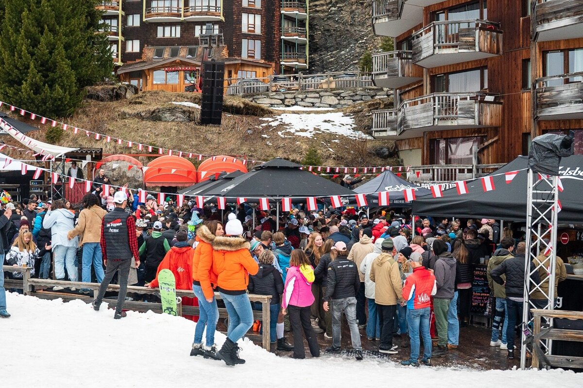 A crowd of people are gathered in front of a tent that says edelweiss