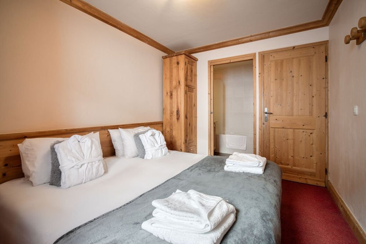 A bedroom with a bed and a wooden door