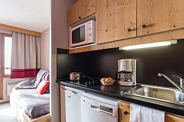 A kitchen with a dishwasher a coffee maker and a microwave