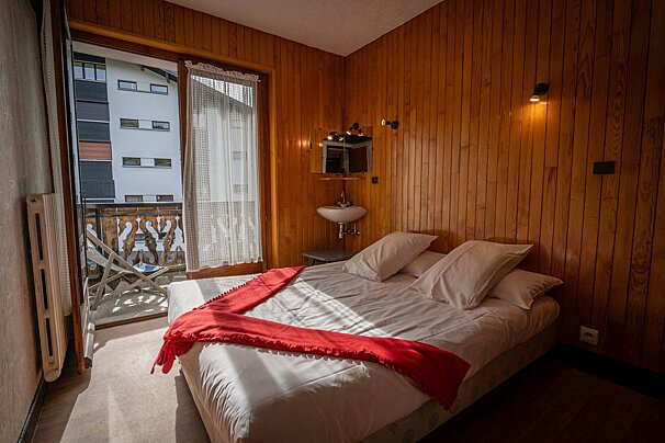 A bedroom with a bed and a sink in the corner
